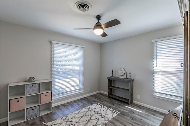 miscellaneous room featuring ceiling fan, dark hardwood / wood-style flooring, and a healthy amount of sunlight