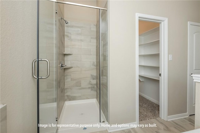 bathroom featuring wood-type flooring and a shower with shower door