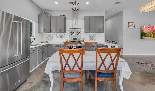 kitchen featuring tasteful backsplash, stainless steel appliances, sink, pendant lighting, and gray cabinets