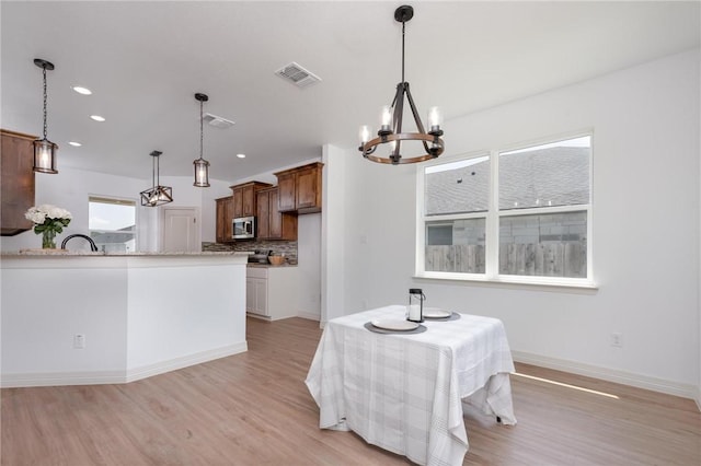 dining room featuring light hardwood / wood-style floors and a notable chandelier