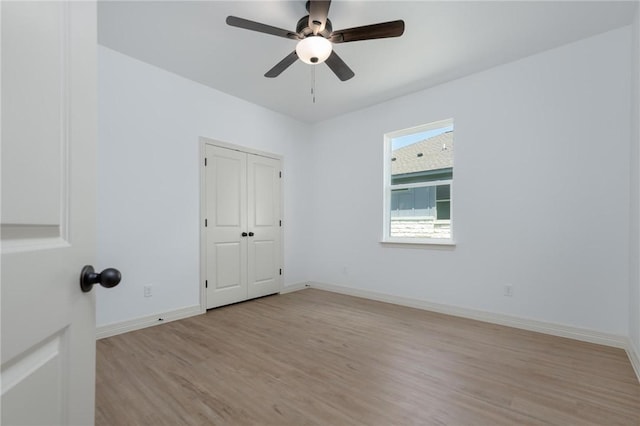 empty room with ceiling fan and light hardwood / wood-style flooring