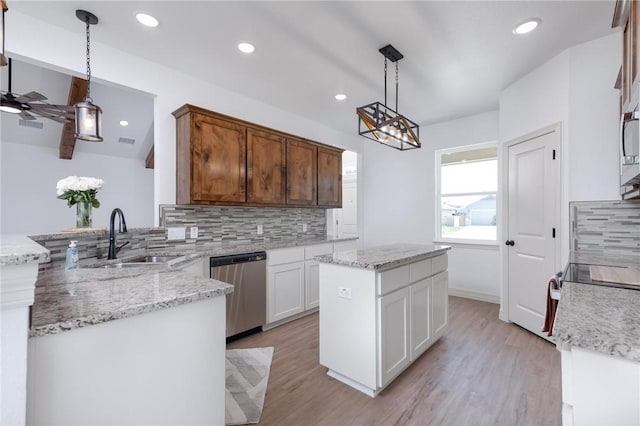 kitchen featuring white cabinets, a center island, decorative light fixtures, and stainless steel dishwasher