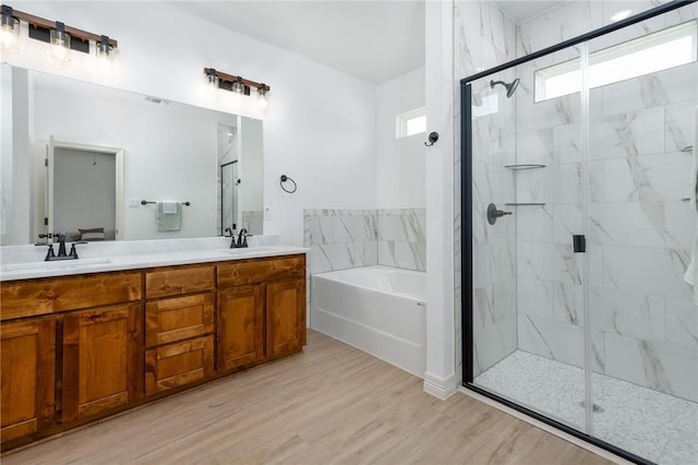 bathroom featuring separate shower and tub, a wealth of natural light, hardwood / wood-style floors, and vanity