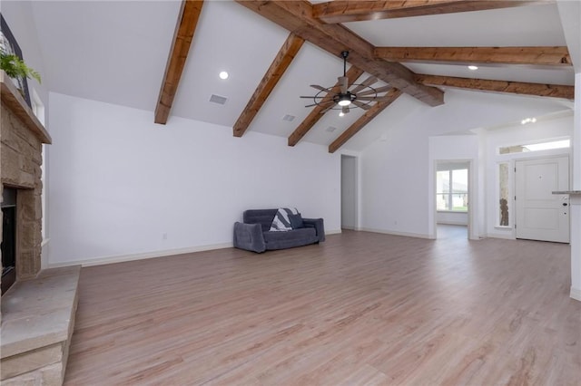 unfurnished living room featuring high vaulted ceiling, ceiling fan, light wood-type flooring, a fireplace, and beam ceiling