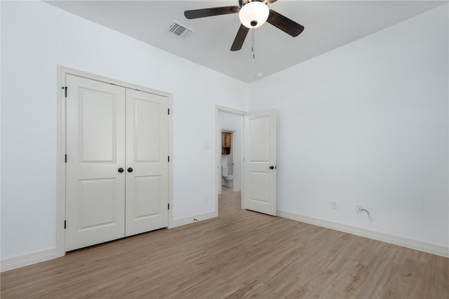 unfurnished bedroom with ceiling fan, light wood-type flooring, and a closet