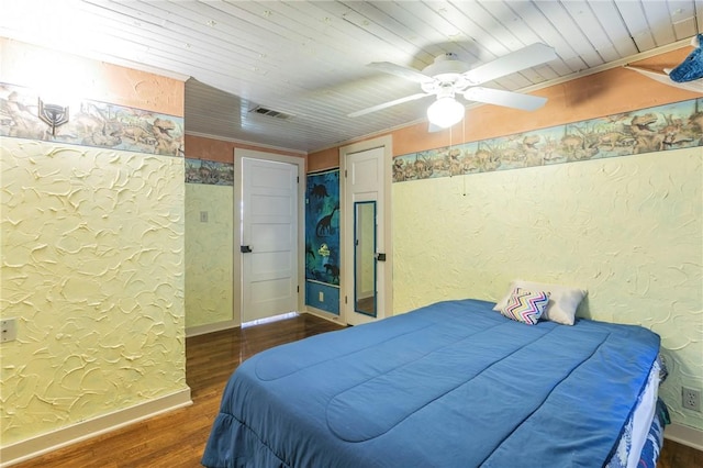 bedroom featuring visible vents, baseboards, wood finished floors, wooden ceiling, and a textured wall