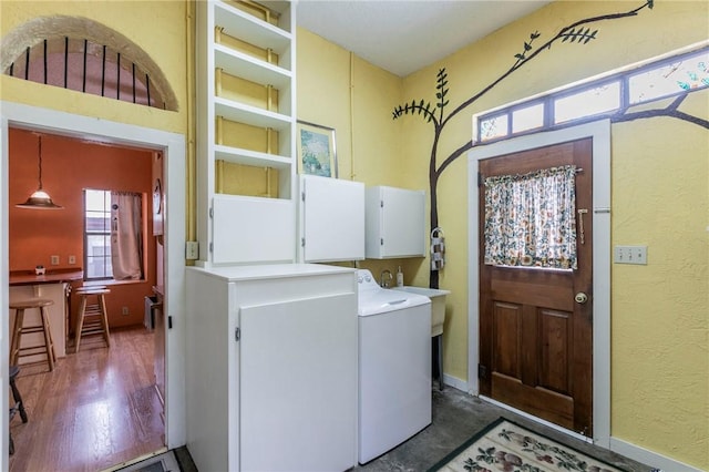 washroom featuring cabinet space, independent washer and dryer, and dark wood finished floors