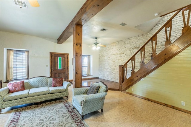 living area with beamed ceiling, ceiling fan, stairway, and visible vents