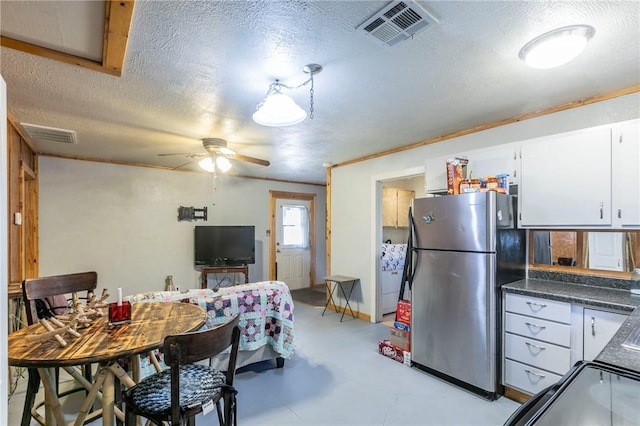 dining area with visible vents, a textured ceiling, concrete flooring, and a ceiling fan