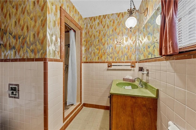 bathroom with vanity, tile walls, and walk in shower