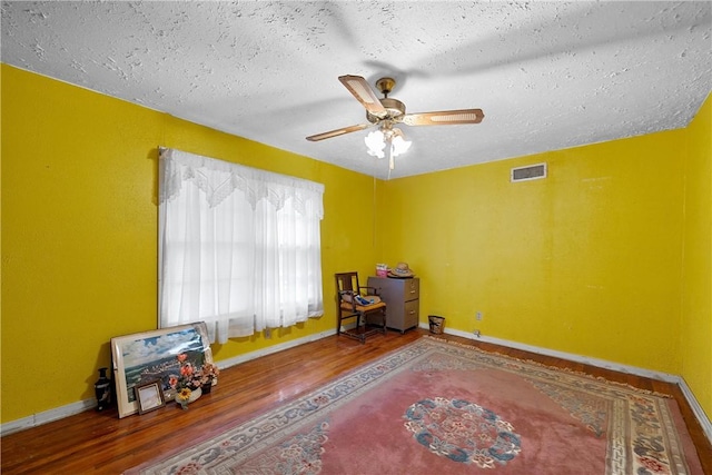 misc room featuring hardwood / wood-style flooring, ceiling fan, and a textured ceiling