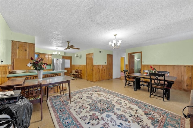 dining space featuring a textured ceiling and ceiling fan with notable chandelier