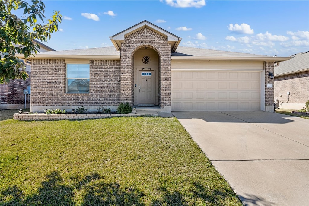 single story home with a garage and a front lawn