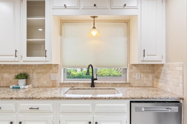 kitchen with a sink, decorative backsplash, white cabinets, glass insert cabinets, and stainless steel dishwasher