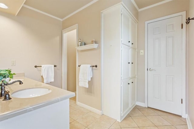 full bathroom with tile patterned flooring, crown molding, baseboards, and a sink