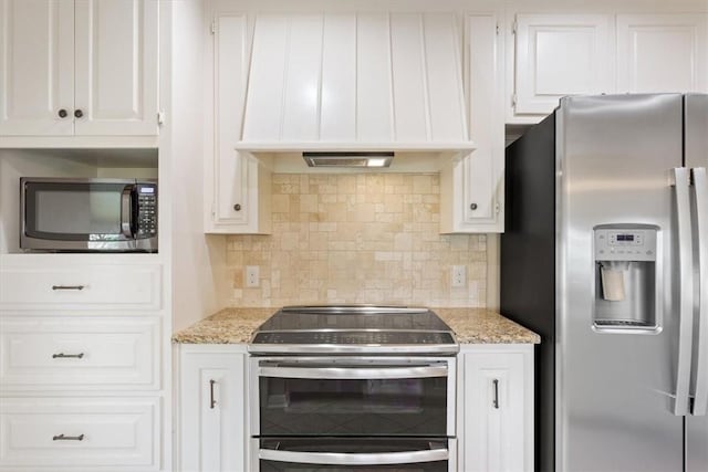 kitchen featuring backsplash, white cabinets, appliances with stainless steel finishes, and premium range hood