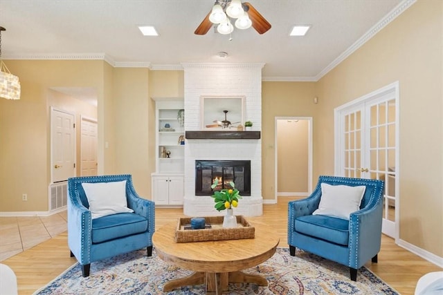 living area with crown molding, built in features, a ceiling fan, and light wood-style floors