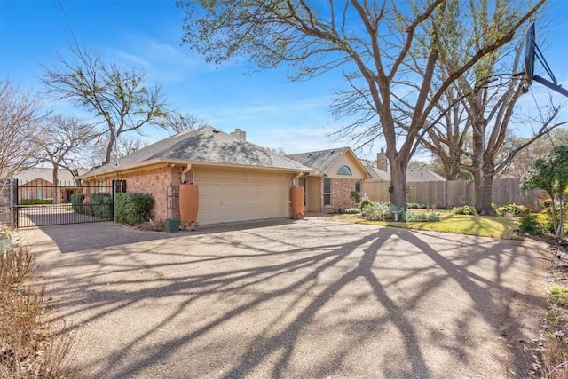 view of front facade with a gate, aphalt driveway, fence, a garage, and brick siding