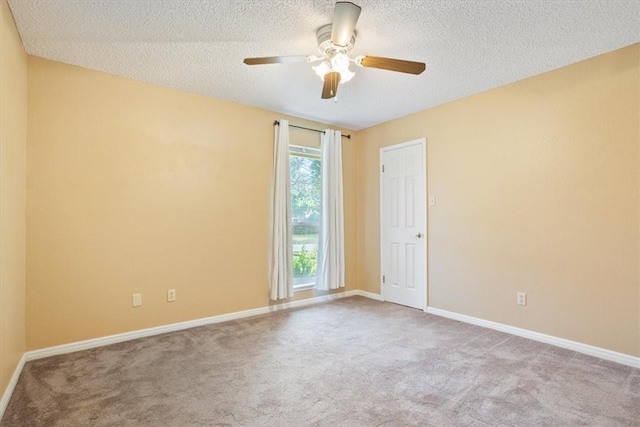 empty room featuring baseboards, carpet flooring, a textured ceiling, and ceiling fan