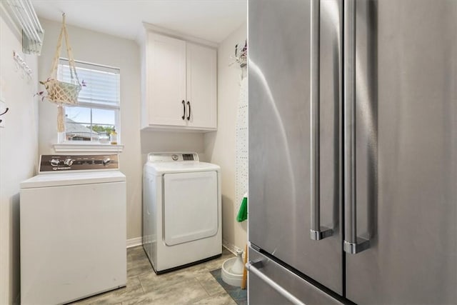 clothes washing area with cabinet space and separate washer and dryer