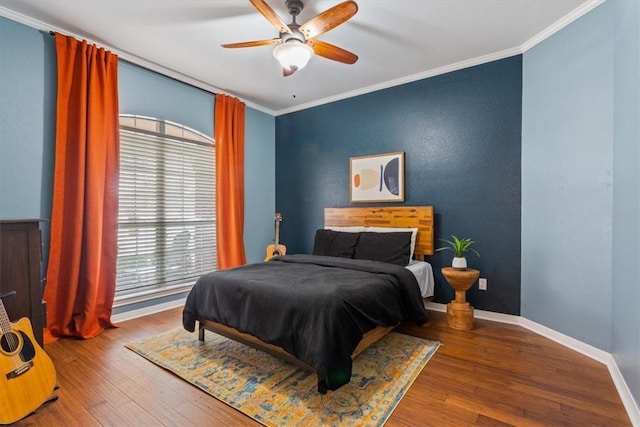 bedroom featuring crown molding, wood finished floors, and baseboards