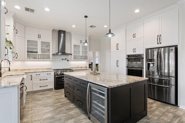 kitchen featuring beverage cooler, a sink, white cabinetry, appliances with stainless steel finishes, and wall chimney range hood