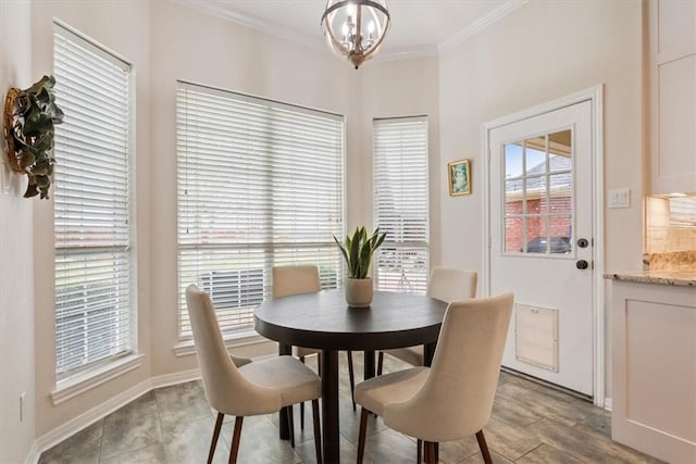 dining space with ornamental molding, a chandelier, and baseboards