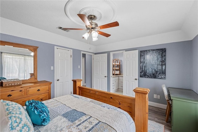 bedroom with ceiling fan, connected bathroom, and hardwood / wood-style flooring