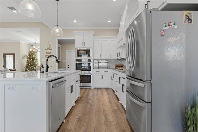 kitchen with decorative light fixtures, white cabinetry, sink, and appliances with stainless steel finishes