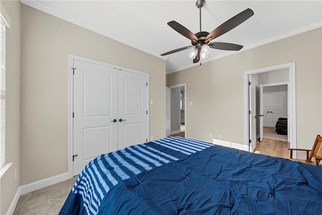 bedroom featuring ornamental molding, a closet, ceiling fan, and light colored carpet