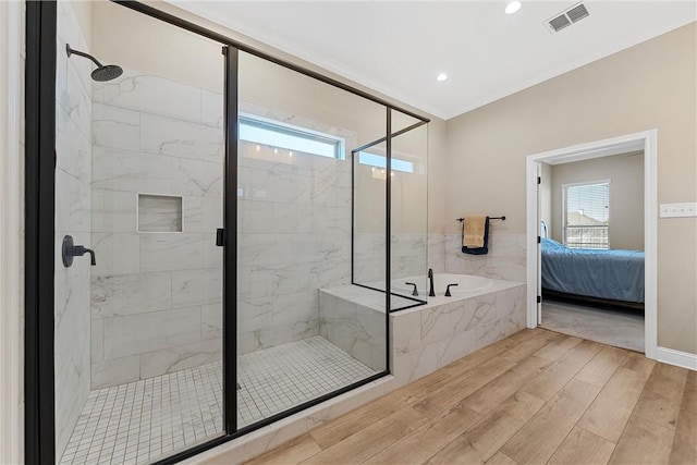 bathroom with hardwood / wood-style floors, separate shower and tub, and a wealth of natural light