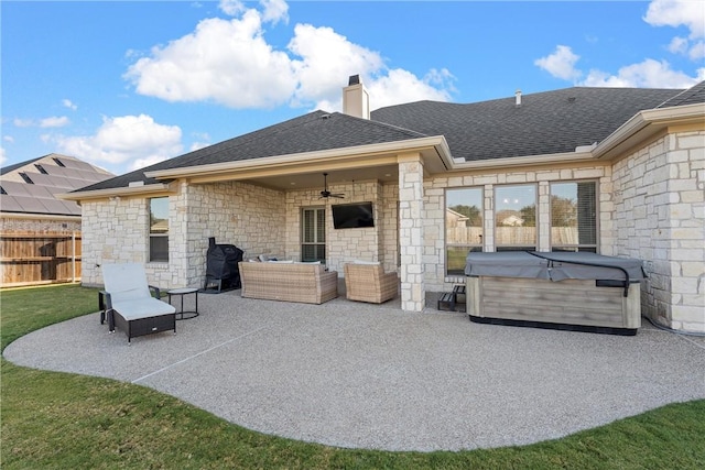 rear view of house with an outdoor living space, a hot tub, ceiling fan, and a patio area