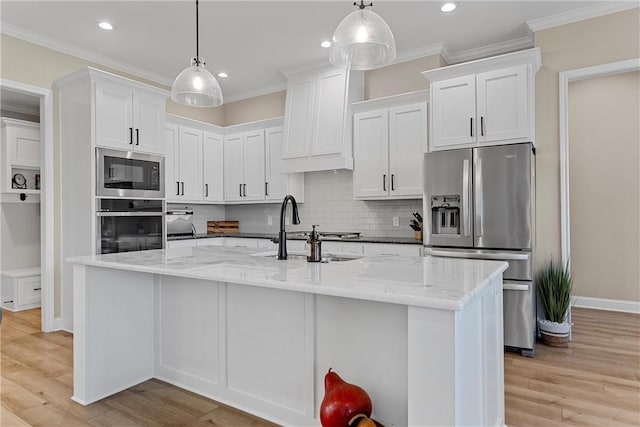 kitchen featuring white cabinets, hanging light fixtures, and appliances with stainless steel finishes