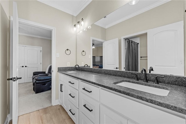 bathroom featuring wood-type flooring, vanity, ceiling fan, and crown molding