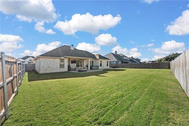 rear view of house with a lawn and a patio