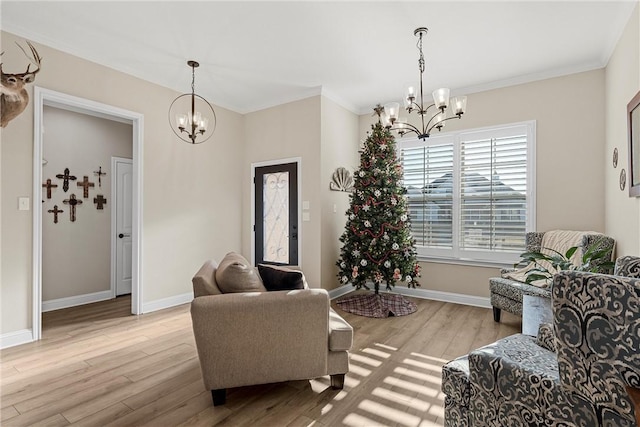 living room with ornamental molding, light wood-type flooring, and an inviting chandelier