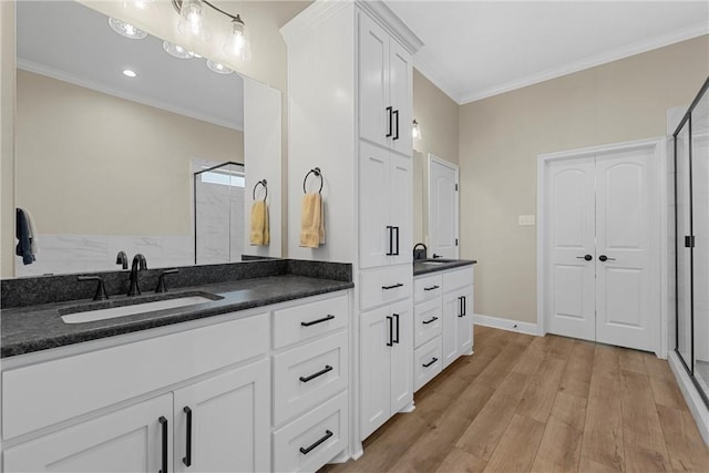 bathroom with hardwood / wood-style floors, vanity, walk in shower, and ornamental molding