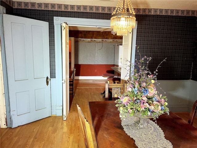 dining room with wood-type flooring and an inviting chandelier