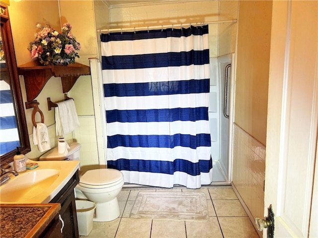 bathroom with tile patterned floors, a shower with curtain, vanity, and tile walls