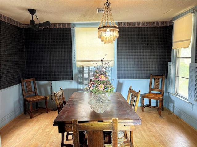 dining room featuring hardwood / wood-style floors, a notable chandelier, and a textured ceiling