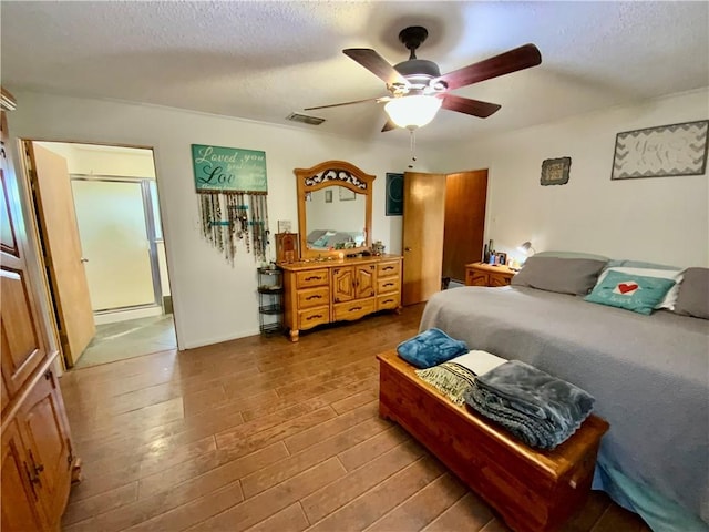 bedroom with ceiling fan, a textured ceiling, and hardwood / wood-style flooring