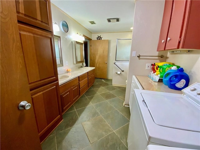 bathroom with tile patterned flooring, vanity, washing machine and dryer, and crown molding