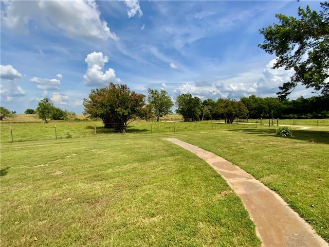 view of property's community featuring a lawn and a rural view