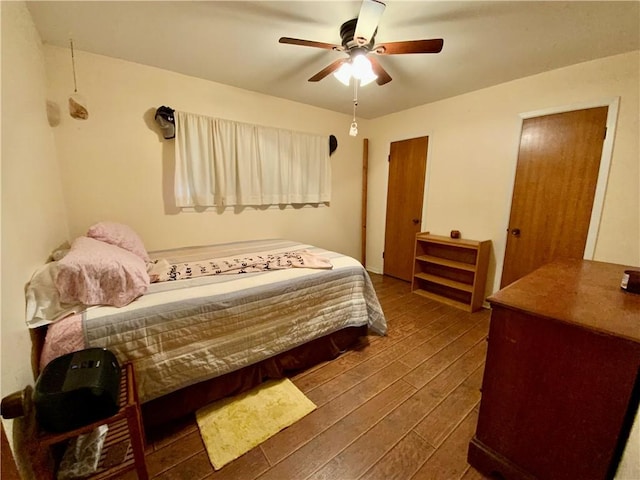 bedroom with ceiling fan and dark wood-type flooring