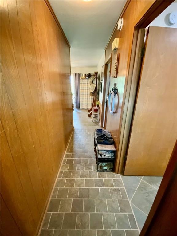 hallway featuring wooden walls