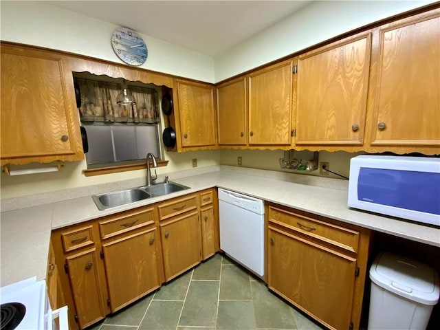 kitchen with dark tile patterned flooring, white appliances, and sink