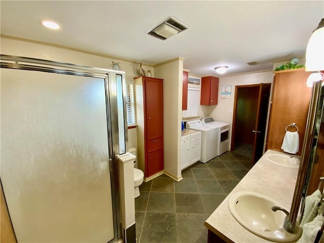 bathroom with independent washer and dryer, vanity, toilet, and an enclosed shower