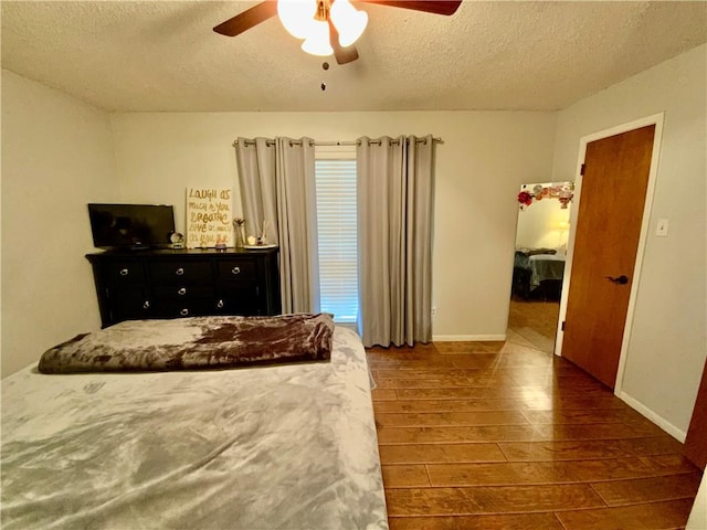 bedroom featuring a textured ceiling, ceiling fan, and dark wood-type flooring