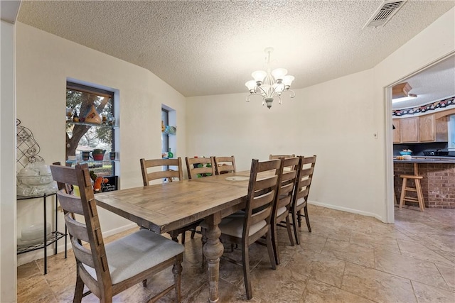 dining room with a textured ceiling and a notable chandelier