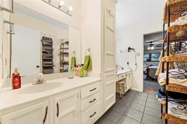 bathroom with tile patterned floors, vanity, ceiling fan, and a textured ceiling